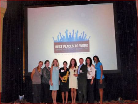 The team at Accountability Resources poses in front of a "Best Places To Work" banner during an awards ceremony.