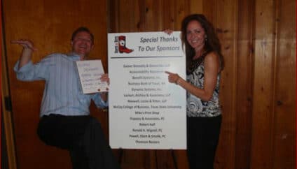 Accountability Resources employees pose in front of a list of sponsors for CPA's Casino Night and Scholarship Fund