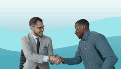 Two young businessmen shake hands with each other as if in agreement or introduction
